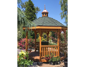 10 Cedar Octagon Belle Roof Gazebo shown with Red Cedar Deck, Rustic Evergreen Asphalt Shingles, 4 Bench sections, Cedar Tongue and Groove Ceiling, Cupola, and Clear Stain/Sealer.