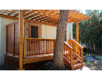 10 x 16 Cedar 2-Beam Wall Mount Pergola shown with cedar stain, lattice wall, 16" top runner spacing, and no deck. 