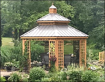 14 Custom Cedar Hexagon Double Roof Gazebo shown with Sandcastle Composite Deck, Custom Lattice Panels, Cupola, and Charcoal Metal Roof.