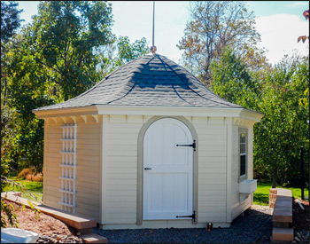 14 Pine Hexagon Belle Cabana shown with Navajo Paint, Asphalt Shingles, One Window, Arched Door, Flower Box, 40" Copper Finial, and Trellis Section.