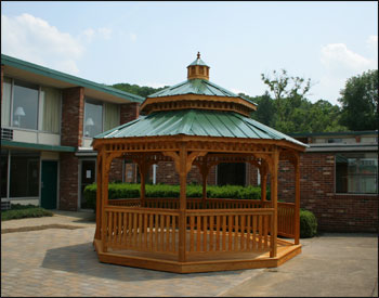 14 Treated Pine Octagon Double Roof Gazebo shown with  Treated Pine Deck, 1 x 3 Standard Railings, Evergreen Metal Roof, and 2 Coats Cedar Tone Stain/Sealer