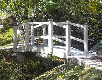 3 x 10 Double Rail Pedestrian Trail Bridge shown with Winchester Gray Trex Deck, White Vinyl Railings, Arctic White Highwood Beam Wrap, 36" High Rails, and Customer Supplied Post Caps.