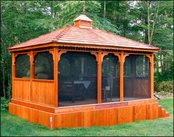 Custom 12x16 Cedar Rectangular Gazebo shown with Cedar Composite Deck, Solid Bottom Railings (no rails in front), Cupola, Screens with  Screen Door, Cedar Shake Shingles, 2 Coats of Cedar Stain Sealer and Customer Built Base. 