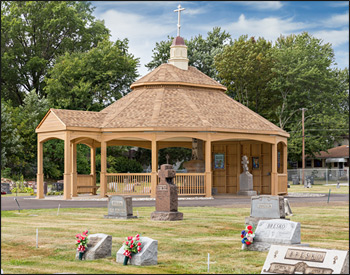 Custom 30 Treated Pine Oval Double Roof Gazebo shown with 42" Tall Railings with 3 Additional Openings, 10" Tall Posts, Arched Beams, Vinyl Finished Ceiling, Harvest Gold Asphalt Shingles, 8/12 Pitch Roof, 3 Full Wall Privacy Walls, Custom Portico, and Custom Fiberglass Cupola.