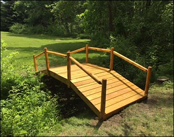5 x 12 Treated Pine Log Rail Bridge with White Cedar Posts and Railings shown with Customers Stain/Sealer.
