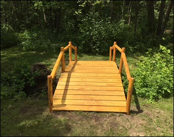 5 x 12 Treated Pine Log Rail Bridge with White Cedar Posts and Railings shown with Customers Stain/Sealer.