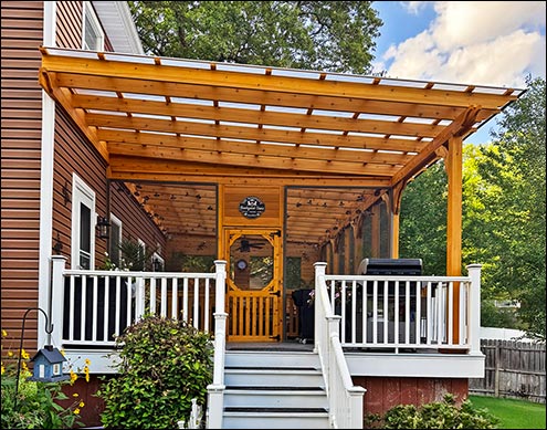 16 x 32 Custom Cedar Wall Mount Pergola shown with Clear Deluxe Polycarbonate Top, a Solid wall on 1 short side with 2 windows/screens, and Full Screens with Screen Door on the other 3 sides of the structure.